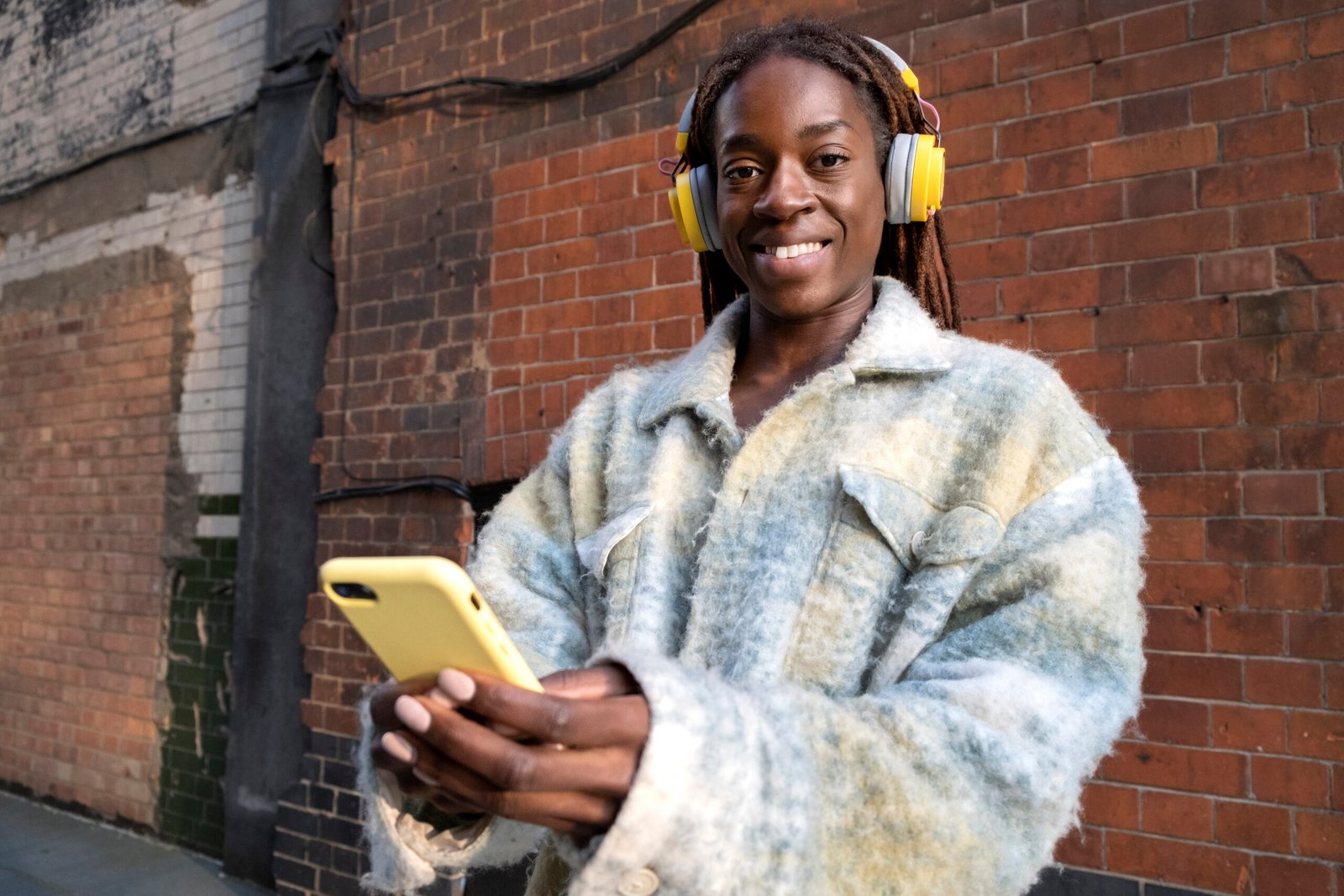 portrait young woman with afro dreadlocks listening music headphones
